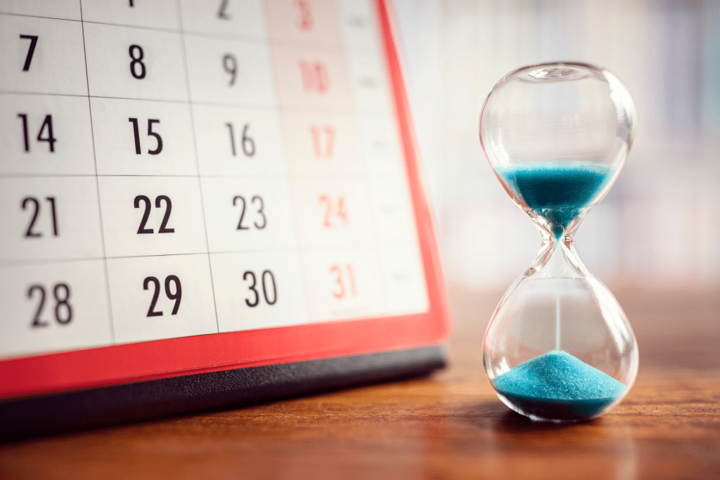 A calendar with an hour glass in front of it